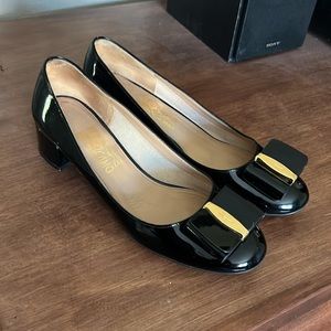 Feragamo black patent leather heels with leather bow adornment.